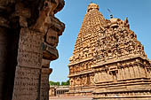 The great Chola temples of Tamil Nadu - The Brihadishwara Temple of Thanjavur. Ancient inscriptions with the temple tower and the auxiliary Subrahmanya shrine in the background. 